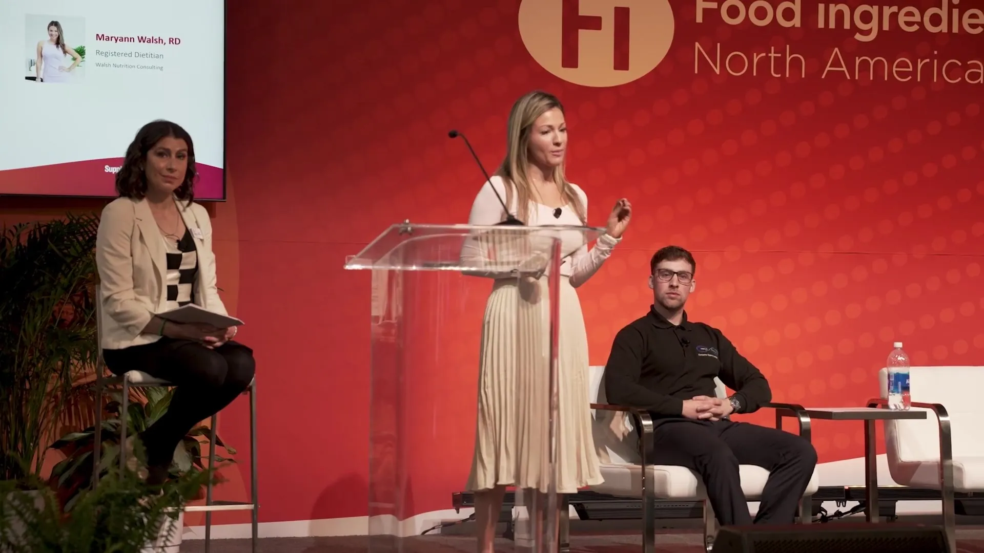 Maryann at the podium on a conference stage